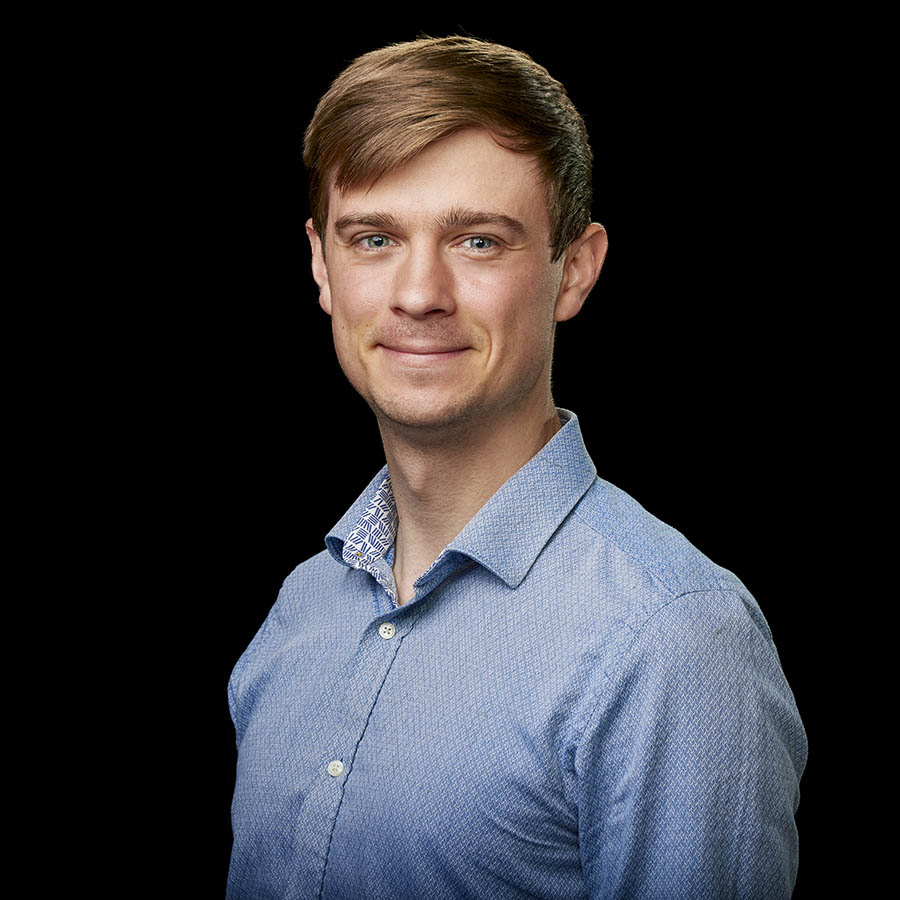 Indoor portrait of white man in blue collared shirt