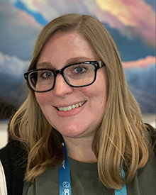 Elsa Gonsiorowski in front of a painted cloud background
