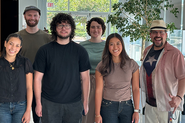 Four students and two mentors pose as a group in the B453 lobby