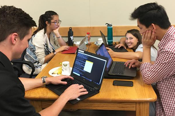 Four students work together at a hackathon