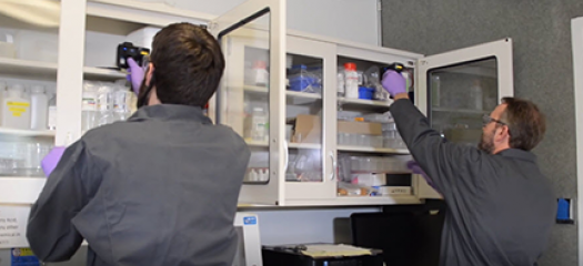 two people conduct RFI scanning in a supply cabinet