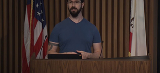 Ian speaking at a podium