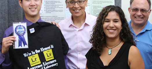 Julia Ramirez smiling as her summer student receives an award at Student Poster session