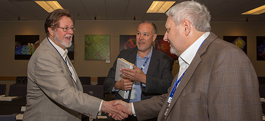 Bill Goldstein (right) shakes hands with San Francisco 49ers chair John York at a meeting on traumatic brain injury research at LLNL