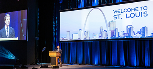 Bronis at a podium kicking off the conference