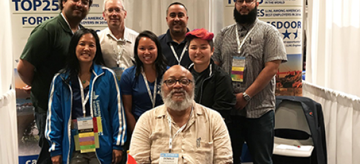 group of diverse Computing employees posing at the Lab's 2019 Tapia Conference recruiting booth