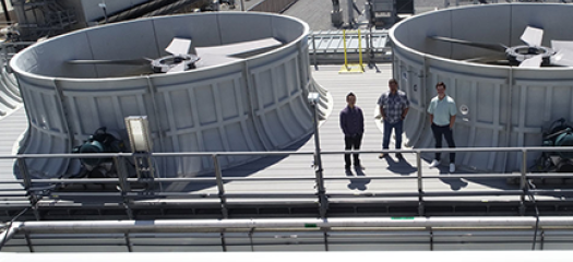 aerial view of three people standing next to the cooling towers