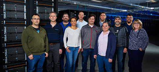 11 members of the Scalable Storage group standing in front of an ASP system