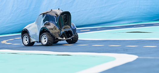 DeepRacer car positioned on the blue track with a dashed yellow center line and white lines marking the outside of the lane