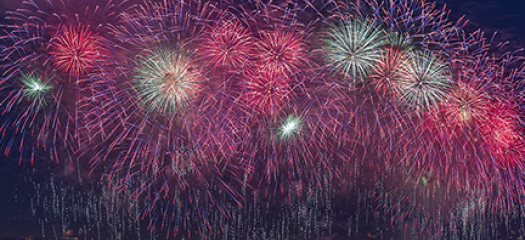 fireworks exploding over a city at night