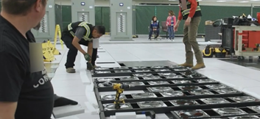 three people install an El Capitan components in the machine room