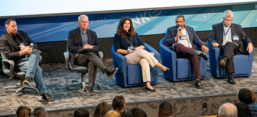 five panelists on a stage in front of an audience