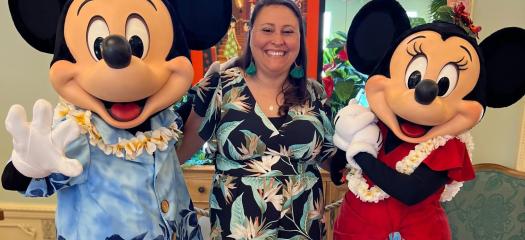 Woman standing between Mickey and Minnie