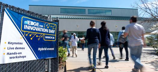 people pass by an outdoor banner advertising the event