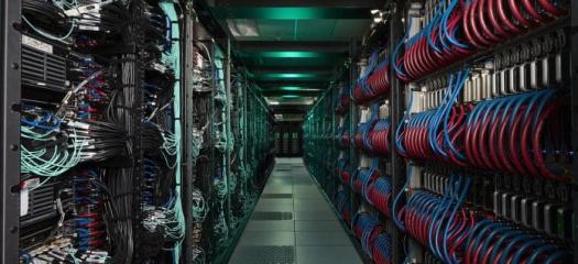 Looking down the row between cabinets at cables and other interior parts of El Capitan