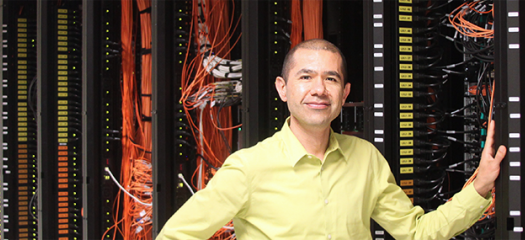 Edgar Leon stands in front of a supercomputer