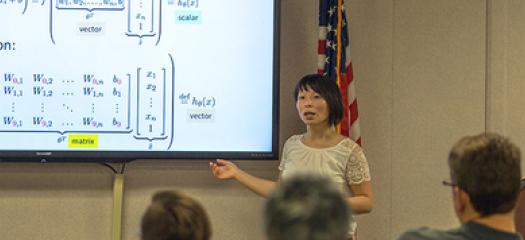 Brenda Ng presents in front of a projection screen