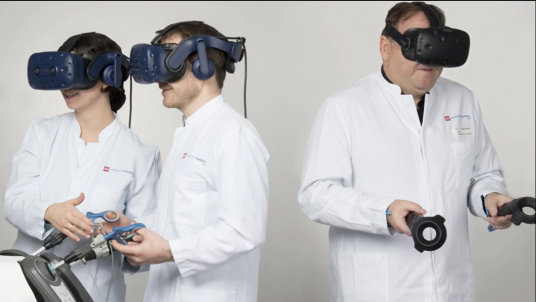 Three surgeons in white coats and VR headsets holding surgical instruments.