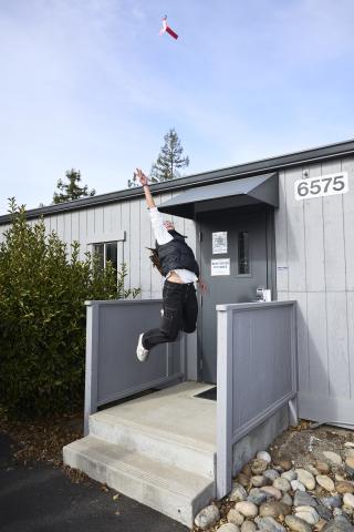 Student jumping in the air throwing a lighted helicopter into the sky