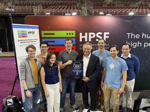Group of award winners accept an award in front of an HPSF banner