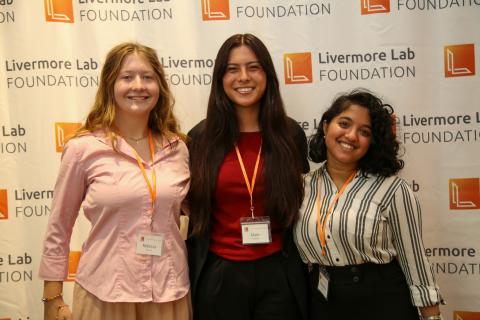 Three students stand in front of a Livermore Lab Foundation backdrop.
