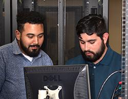 two students confer at a computer workstation