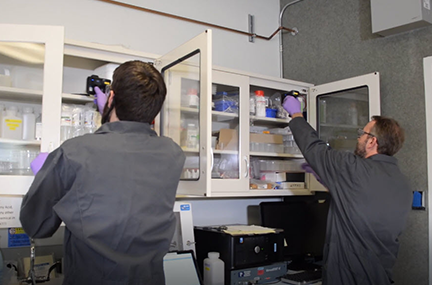 two people conduct RFI scanning in a supply cabinet