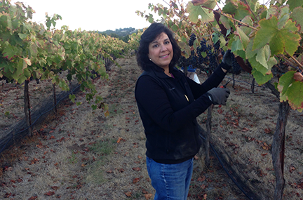 Anna Maria trims vines in her vineyard