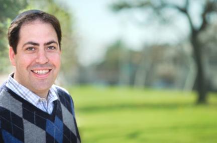 Outdoor portrait of white male with dark hair smiling at the camera