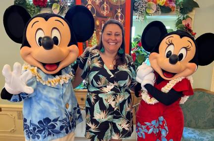 Woman standing between Mickey and Minnie