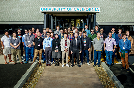 dozens of workshop participants pose as a group outside the UCLCC building