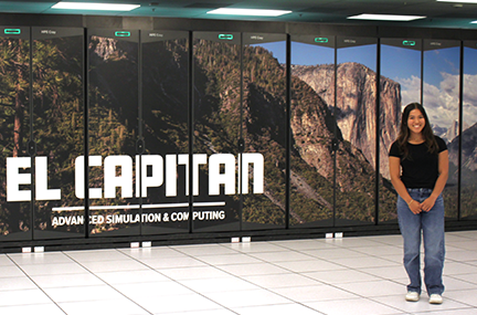 an intern stands next to the El Capitan supercomputer