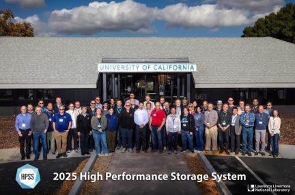 Several dozen people are posed outside one of LLNL’s buildings used to host collaboration visits.  