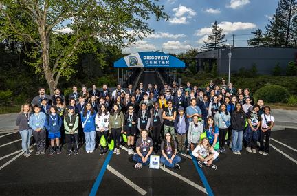 Large group of mostly students poses outside of the LLNL Discovery Center