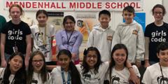 Girls Who Code students and volunteers pose as a team