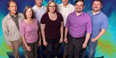 seven people in front of an abstract simulation background