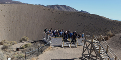A group poses beside the Sedan Crater during a 2018 tour of NNSS