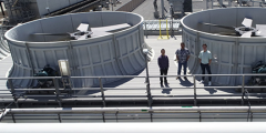 aerial view of three people standing next to the cooling towers