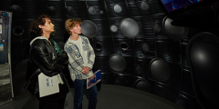 two people inside the NIF target chamber replica