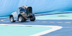 DeepRacer car positioned on the blue track with a dashed yellow center line and white lines marking the outside of the lane