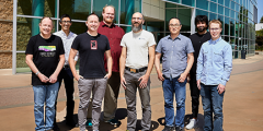 Flux team members posed as a group outside building 453