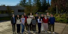 Thirteen visiting students from Colorado College pose outdoors.