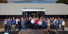 Several dozen people are posed outside one of LLNL’s buildings used to host collaboration visits.  