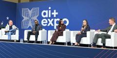 five panelists sitting in white chairs on a blue stage with AI+ Expo backdrop
