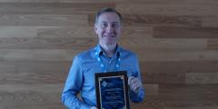 Markus Schordan holds up the plaque honoring the LLNL team’s Test of Time Award for their 2016 paper on Backstroke. 