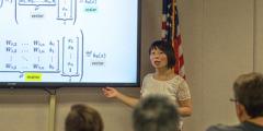 Brenda Ng presents in front of a projection screen
