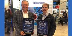 two men holding award plaques