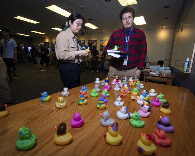 Dev Day participants looking at a table of colorful rubber ducks.
