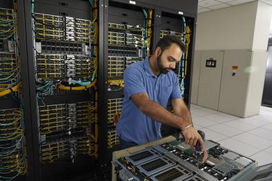 Raj working on the guts of a computer in the machine room